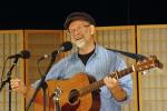 Tom Neilson performing with his guitar