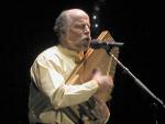 photo of John McCutcheaon playing autoharp in concert.